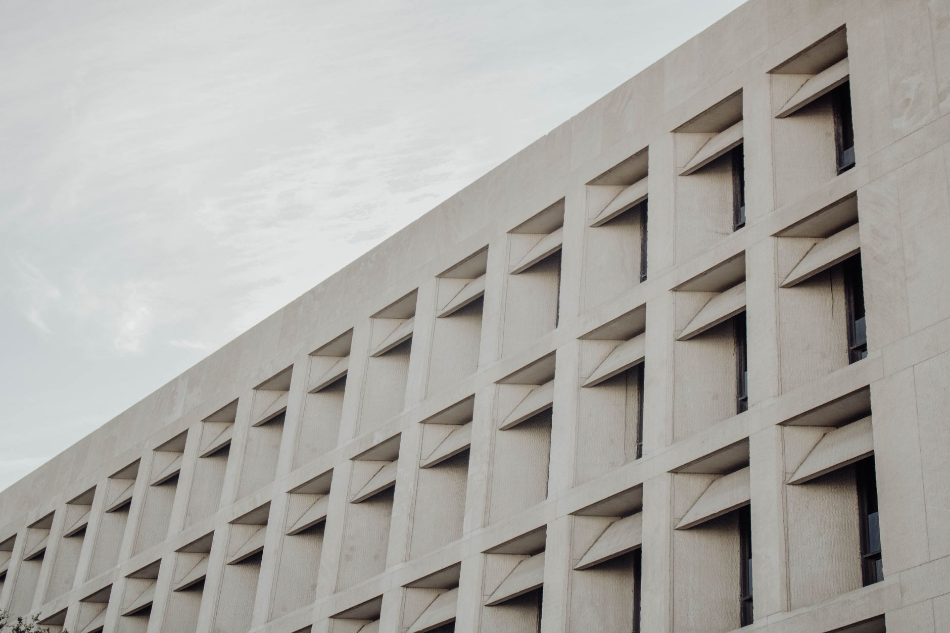 Low-angle view of a modern concrete building facade in Austin, TX